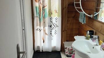 A bathroom with a shower curtain, a sink, and a towel rack.