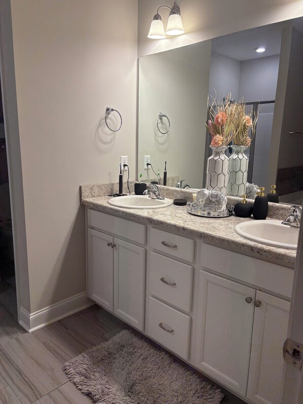 A modern bathroom with two sinks, a large mirror, and a decorative vase. - 10 minutes from Augusta National. Wonderful 4-bedroom house awaits you!!! (Augusta)