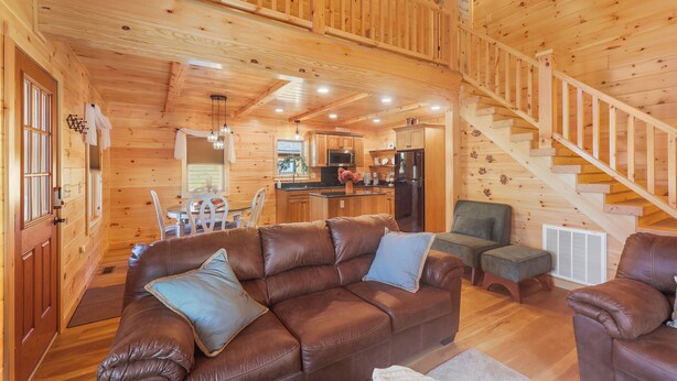 A wooden cabin interior with a living room, kitchen, and staircase. - Seasons on Oak Short walk to best Fly Fishing in Northeast Cozy Cabin Deposit NY (Deposit)