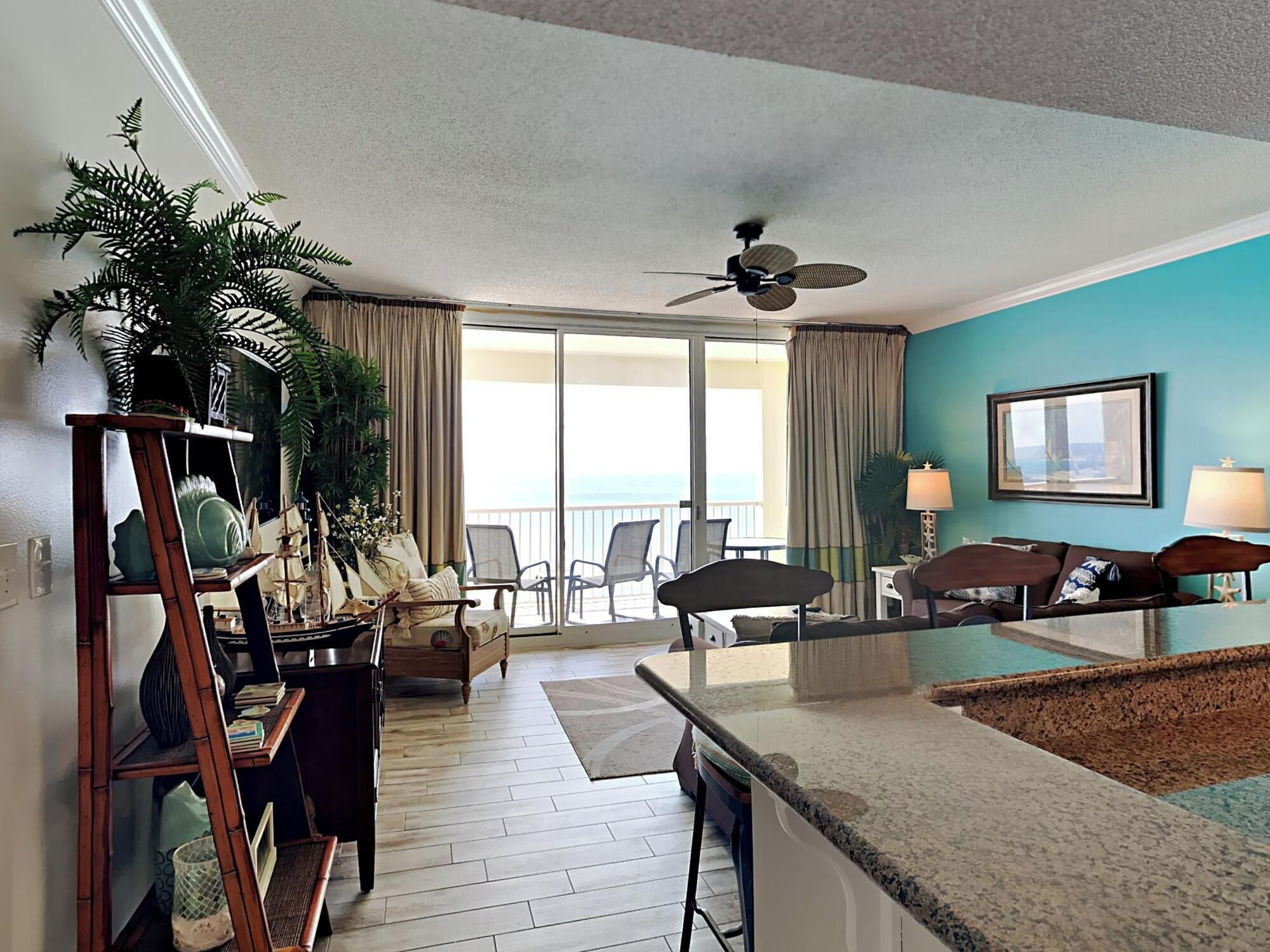 Habitación de hotel con balcón, zona de comedor y sala de estar con vista al océano.
