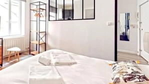A bedroom with a bed, a wardrobe, a mirror, and a radiator. - TIGER ROOM - Studio Gailleton Place Bellecour (Lyon)