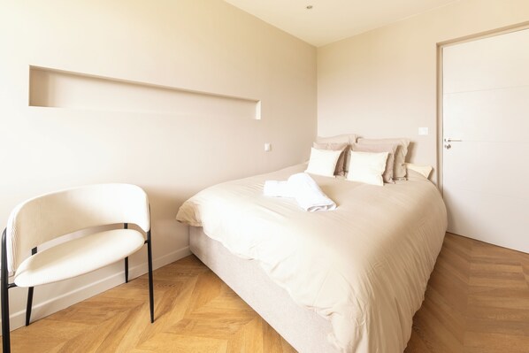 A bedroom with a bed, a chair, and a door. - Mat&Ness Luxury (Beauvais)