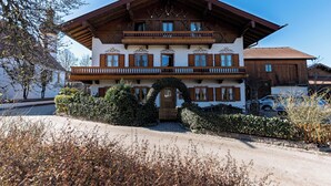 A traditional chalet-style building with a wooden facade, a balcony, and a well-maintained garden.