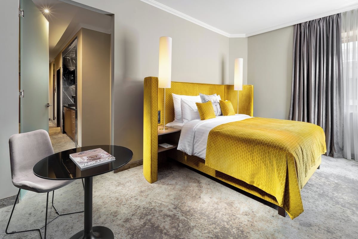 A hotel room with a bed, a desk, and a chair.