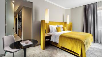 A hotel room with a bed, a desk, and a chair.