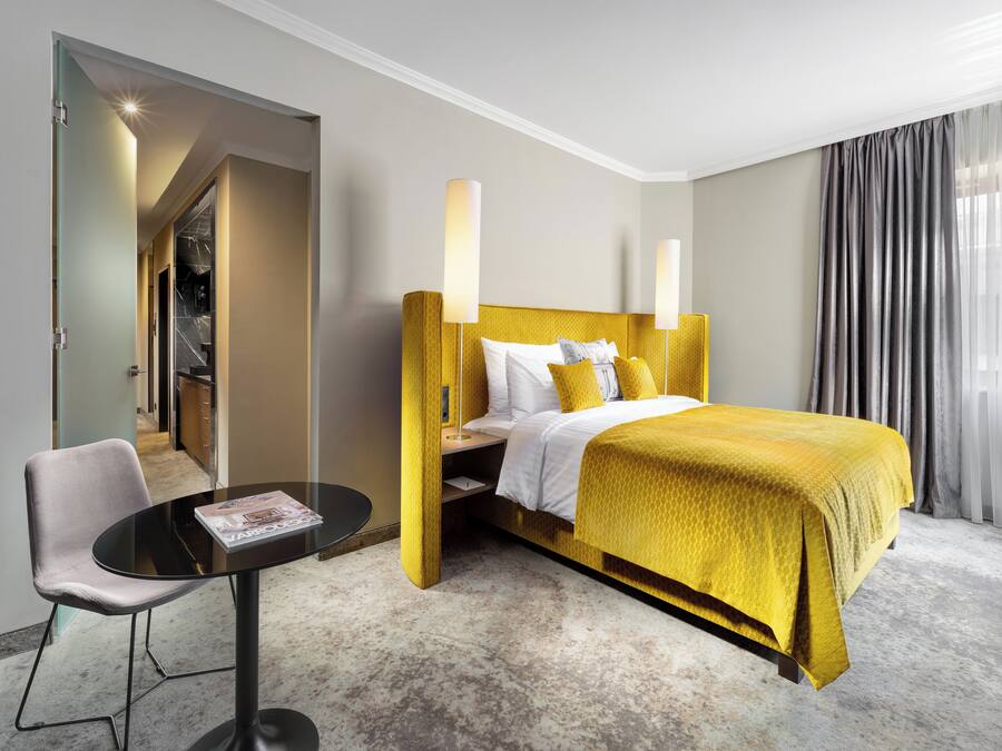 A hotel room with a bed, a desk, and a chair.