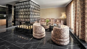 Een moderne lobby met een marmeren vloer, gestreept banken en een decoratieve wand.