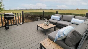 Una terraza al aire libre con una parrilla, un sofá y una mesa.