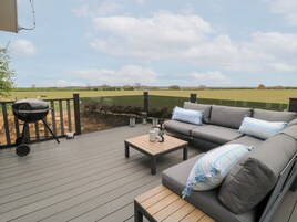 Una terraza al aire libre con una parrilla, un sofá y una mesa.