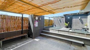 Un sauna public doté d’une clôture en bois, d’une horloge et d’un panneau indiquant que l’accès est réservé au personnel.