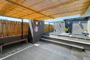 A public sauna with a wooden fence, a clock, and a sign indicating staff-only access. - Azumaya Hotel Dao Tan (Hanoi)