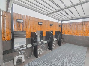 A public restroom with bamboo partitions, individual sinks, and mirrors. - Azumaya Hotel Dao Tan (Hanoi)