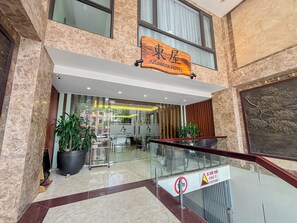 The entrance of Azumaya Hotel with a modern design, marble flooring, and potted plants. - Azumaya Hotel Dao Tan (Hanoi)