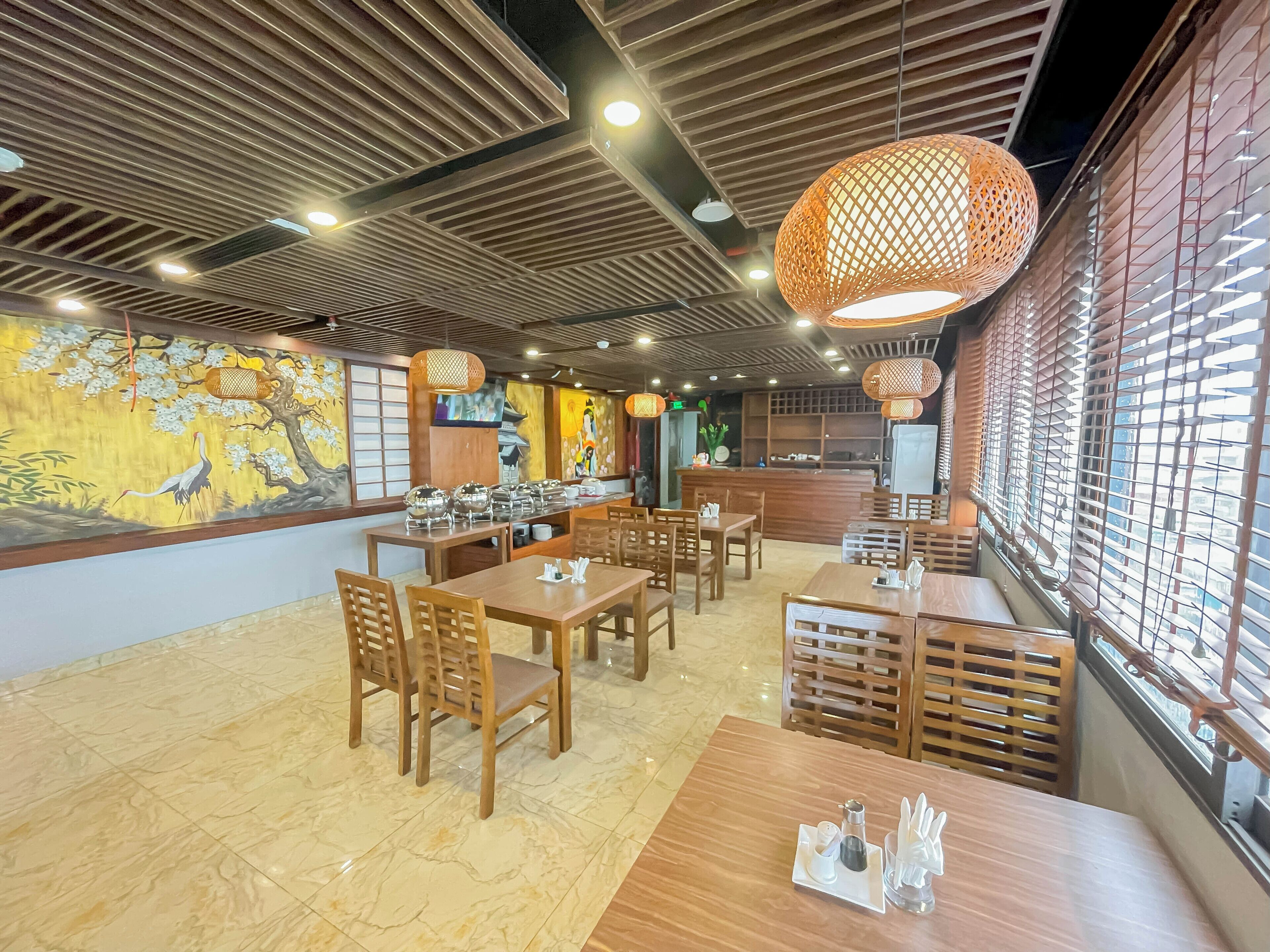 Een restaurant met houten tafels en stoelen, een buffetopstelling en een muurschildering.