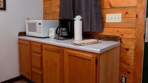 Eine Küchenzeile mit Mikrowelle, Kaffeemaschine und einem Handtuch auf der Arbeitsfläche.
