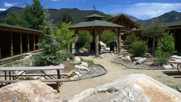 Eine Lodge mit Holzbauten, Picknicktischen und einem zentralen Gazebo.