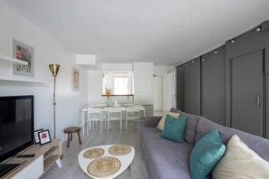 Relax in this stylish living space with a flat-screen TV, comfortable sofa, and dining area.