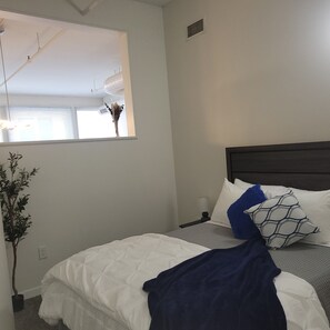 A bedroom with a bed, a window, a plant, and a ceiling fan. - #4 Downtown Free Parking- Walk to Lucas Oil, Conv Center, Gainbridge (Indianapolis)