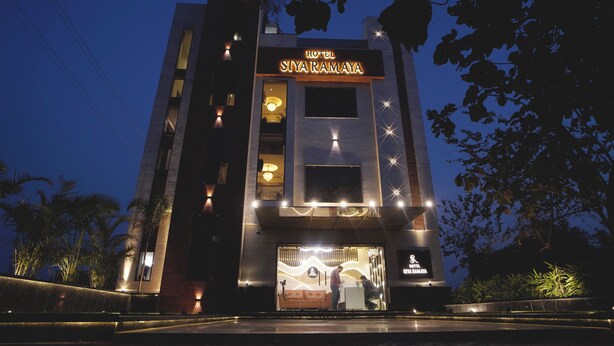 Ett modernt hotell med en tydlig skylt som visar texten ”HOTEL SIYARAMAYA” och en väl upplyst entré.