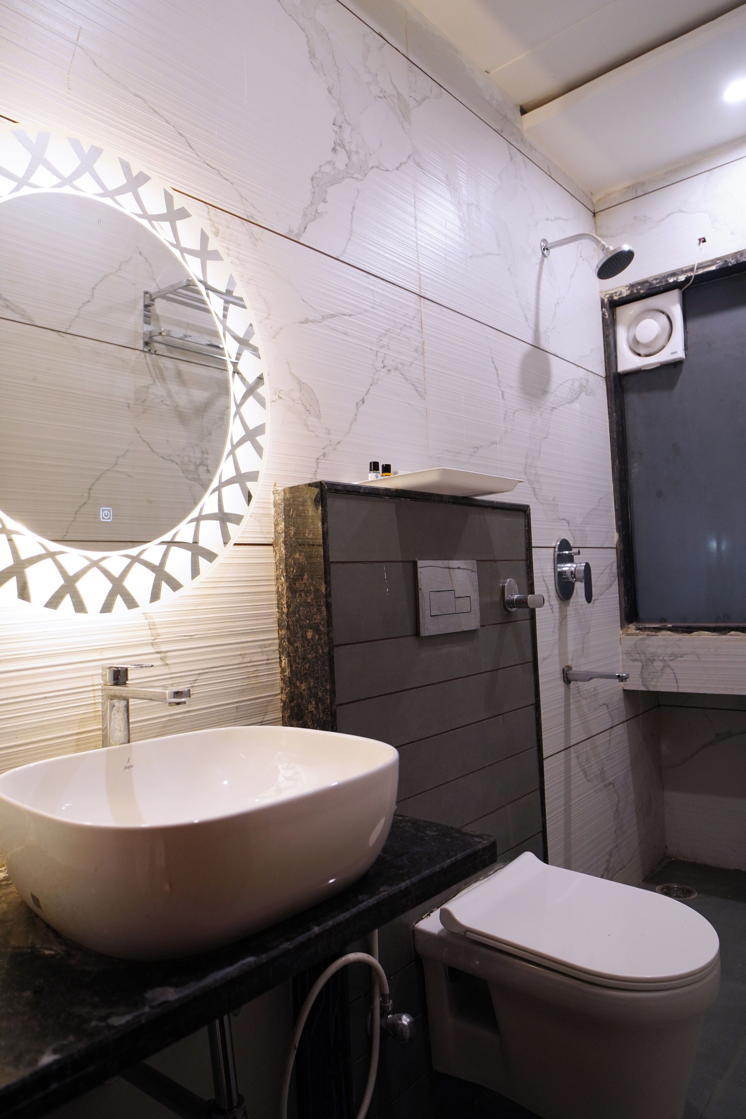 A bathroom with a large oval sink, a toilet, and a shower.