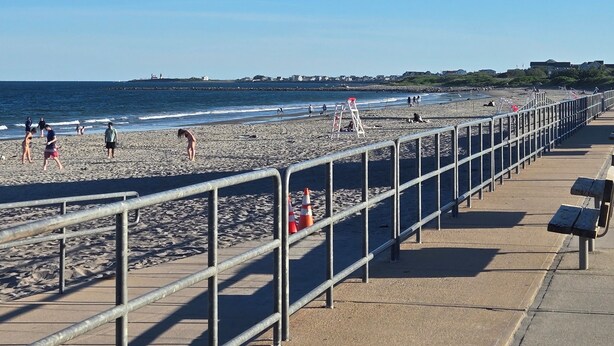 A beach with a metal railing, a concrete walkway, and a clear blue sky. - Returning to the summer rental market fully renovated 4 Br/2 bath home A/C (Narragansett)