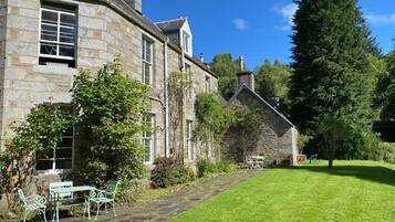 A stone building with a garden and outdoor seating area.