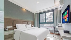 A hotel room with a bed, bedside table, and a window with a city view. - Man'ai Hotel (Shanghai)