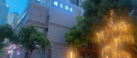 A building with a sign that reads '婚宴酒店' in the evening.
