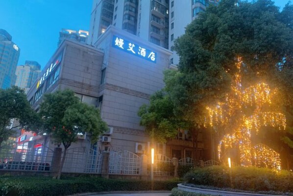 Un edificio con un cartel que dice '婚宴酒店' al caer la noche.