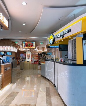 A food court with a counter named 'happy lemon' and a digital menu display. - Man'ai Hotel (Shanghai)