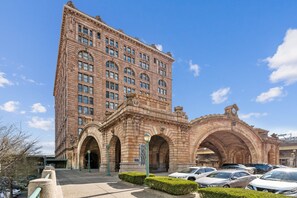 A historic building with a large arched entrance, multiple windows, and a clock tower. - Placemakr Downtown Pittsburgh at The Pennsylvanian (Pittsburgh)