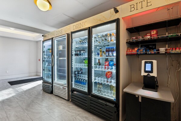 A self-service beverage station with two refrigerators labeled "DINE" and "DRINK," and a payment kiosk. - Placemakr Downtown Pittsburgh at The Pennsylvanian (Pittsburgh)