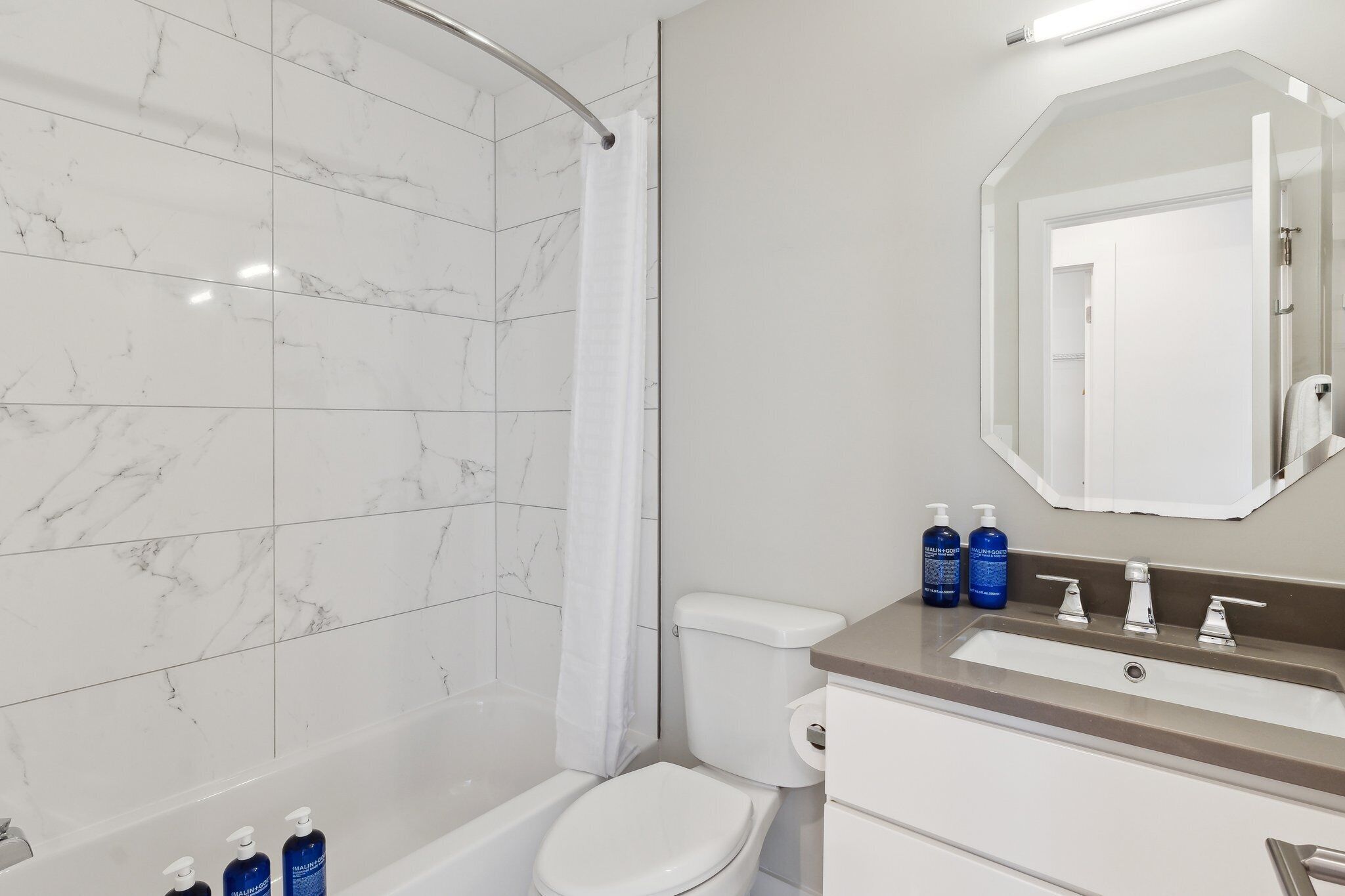 A modern bathroom with a bathtub, toilet, and sink.