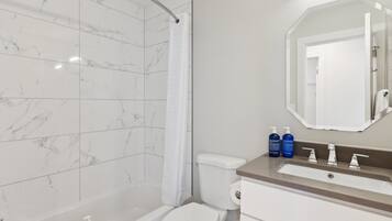 A modern bathroom with a bathtub, toilet, and sink.