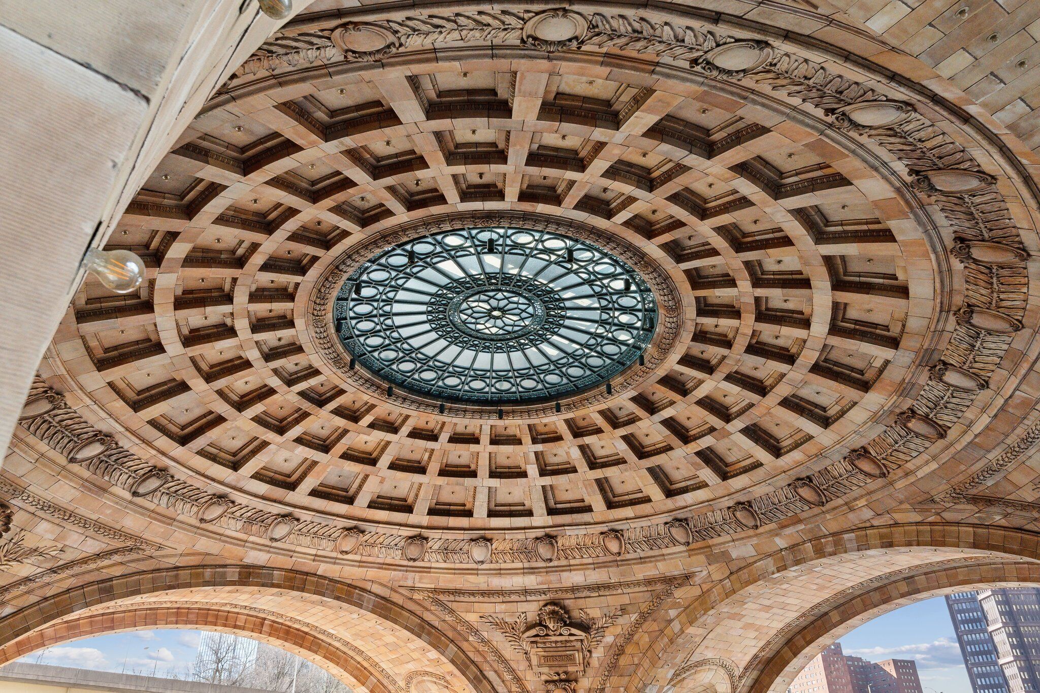A detailed architectural ceiling with a central circular window and ornate stonework.