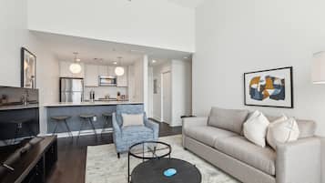 A modern living room with a sofa, a coffee table, and a blue armchair.