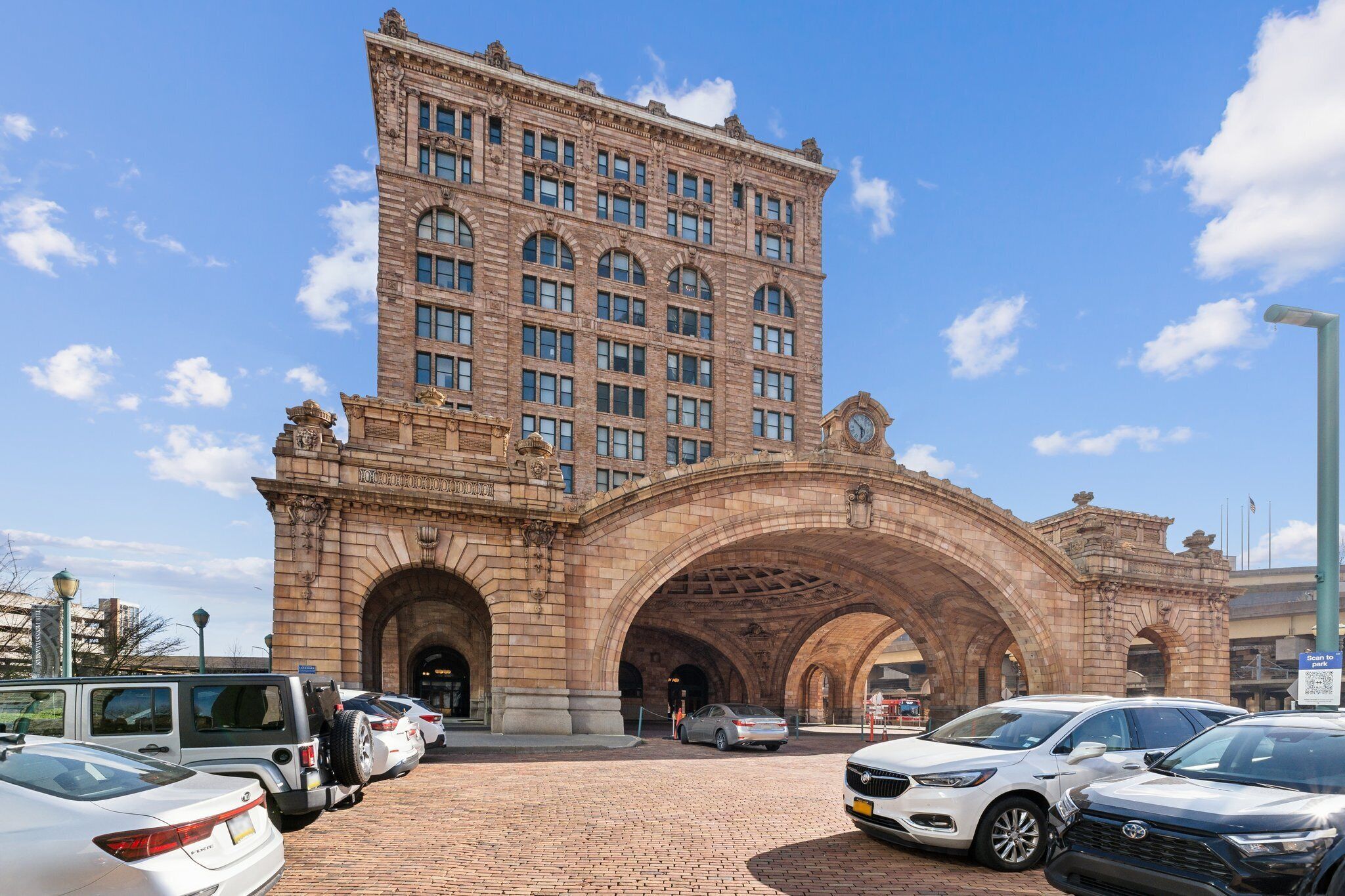 A historic building with a large arched entrance, multiple windows, and a clock tower.