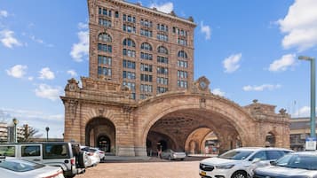 A historic building with a large arched entrance, multiple windows, and a clock tower.