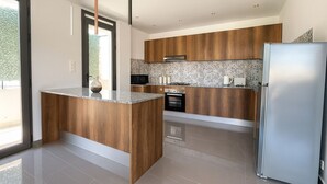 A modern kitchen with a wooden island, stainless steel appliances, and a large refrigerator. - Appartement de 3 pieces a Birkhadem (Algiers)