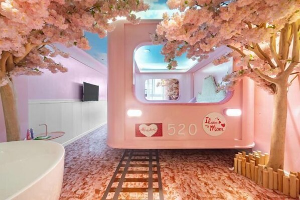 Une pièce décorée dans des tons roses, avec une grande fenêtre, un autocollant en forme de cœur et le chiffre 520.