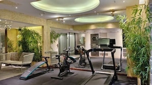 A modern home gym with exercise equipment, including treadmills and stationary bikes, and a large mirror. - KINCO Hotel (Huizhou Huiyang Station) (Huizhou)