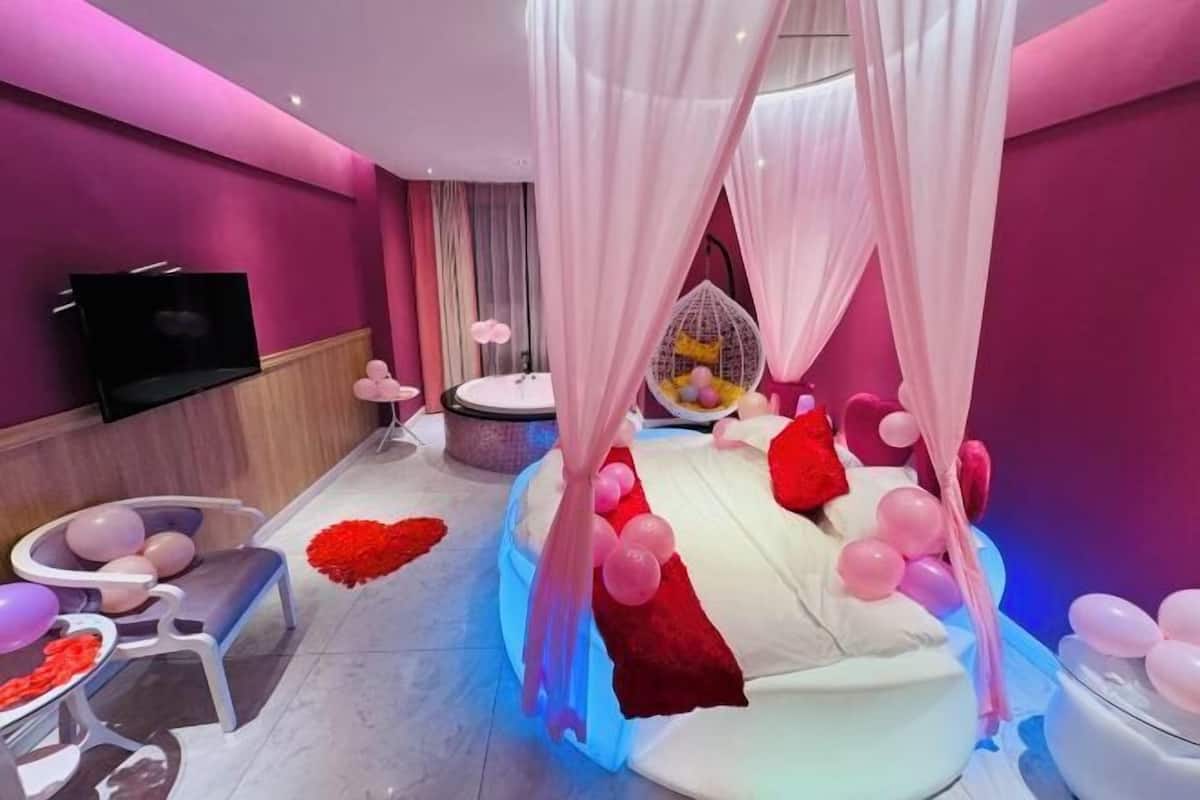 Ein Zimmer mit Bett, Fernseher, Stuhl und Tisch.