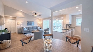 Un appartement moderne comprenant un coin repas, une cuisine, un salon et un balcon avec vue.