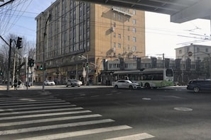 A street intersection with a tram, buildings, and a pedestrian crossing.