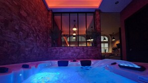 Ein Whirlpoolbereich mit Steinwänden und Blick ins Innere.