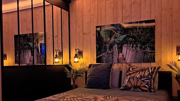 Ein Schlafzimmer mit einem großen Bett, Holzwandverkleidung und zwei Wandlampen.