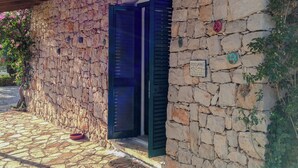 A stone building with a door opening to a dark interior. - Villa Le Cicale - Salento (Morciano di Leuca)