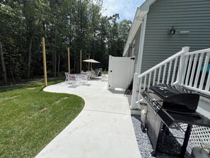 A patio with a barbecue grill, outdoor furniture, and a white gate. - Beach House By The Bay, 9 Car Parking, Linen Included (Lower Township)