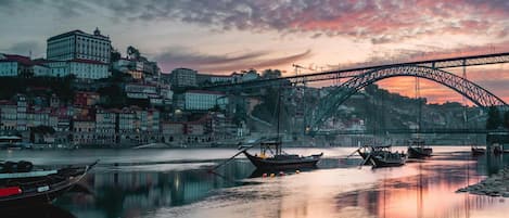 Un río con barcos, un puente y edificios al fondo.