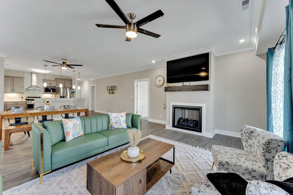 A modern living room with a green sofa, a wooden coffee table, and a fireplace.